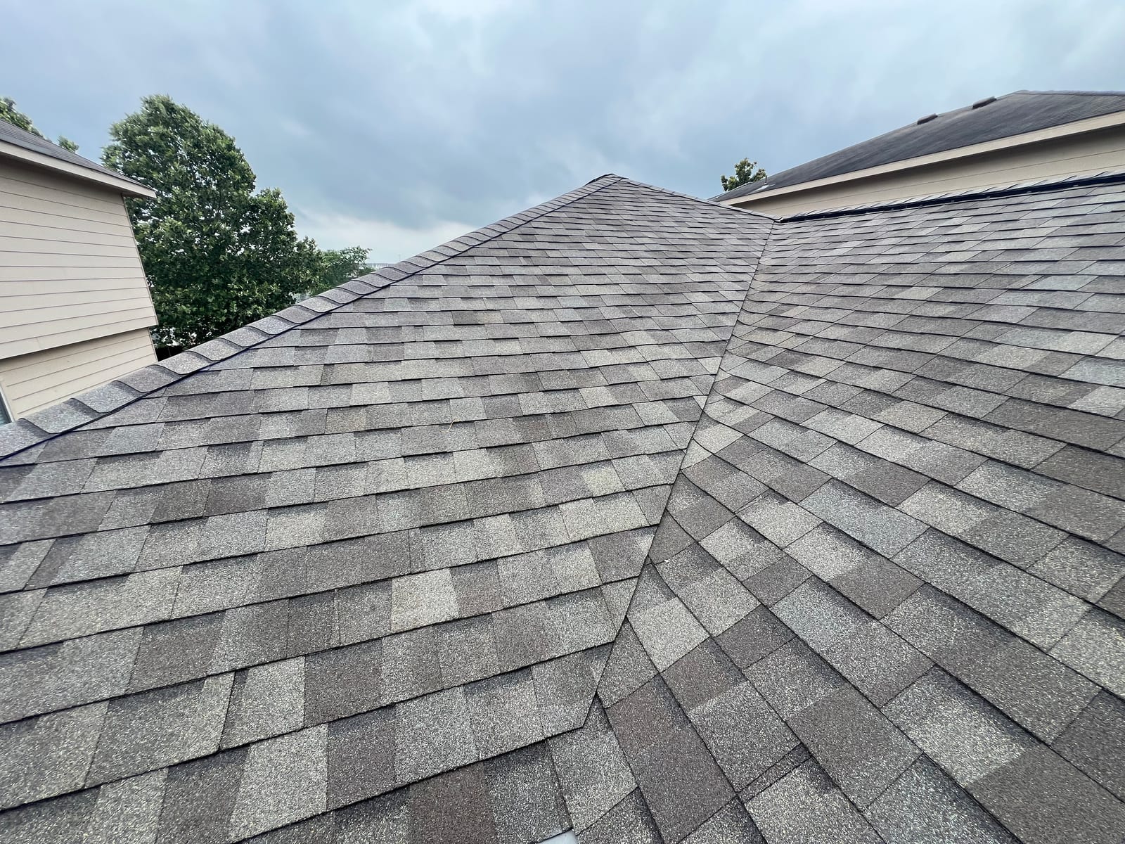 Hip lines meeting on a newly shingled two-story roof