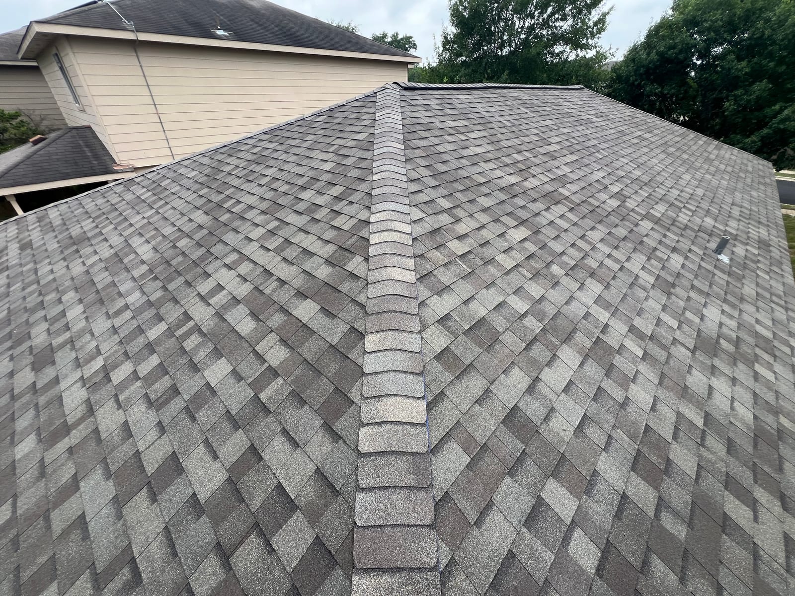 Ridge cap shingles running the length of the roof above a ridge vent