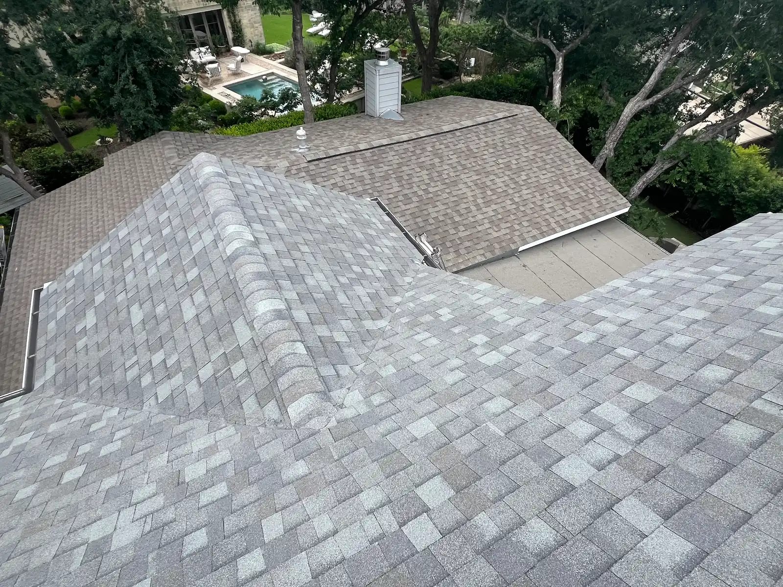 New gray architectural shingles on the upper roof planes with a lower section stripped to the deck